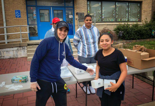 Danny handing out a meal to community member