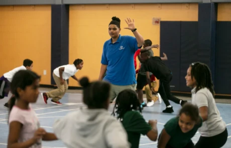 Destiny Smith directs kids playing games in the gymnasium at the Long Branch Unit